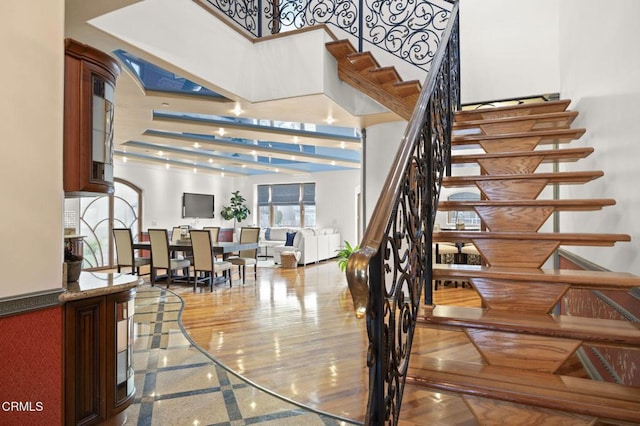 stairway with granite finish floor and a towering ceiling