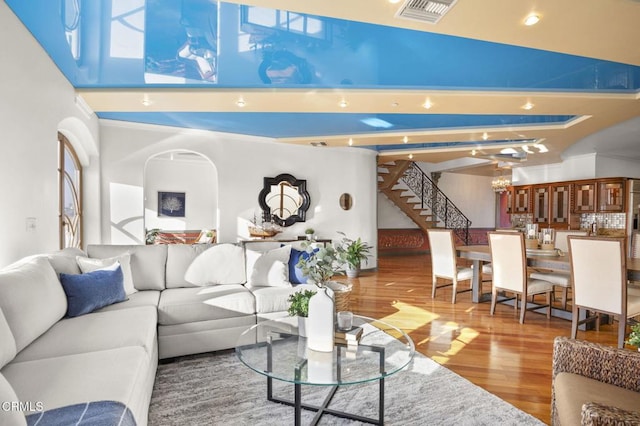 living area featuring wood finished floors, visible vents, and stairs