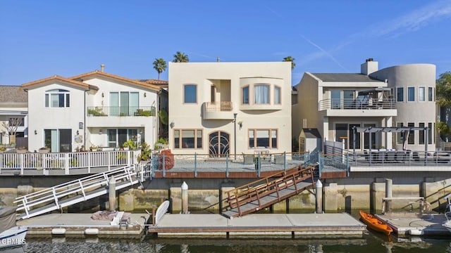 rear view of property featuring a water view and stucco siding