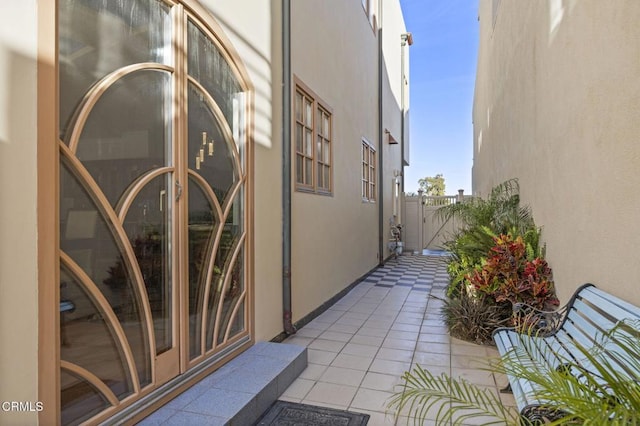 exterior space with stucco siding, a gate, and a patio