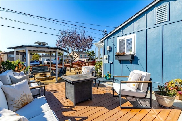 wooden terrace featuring an outdoor living space with a fire pit