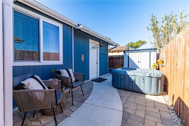 view of patio / terrace with an outbuilding, a shed, and a fenced backyard