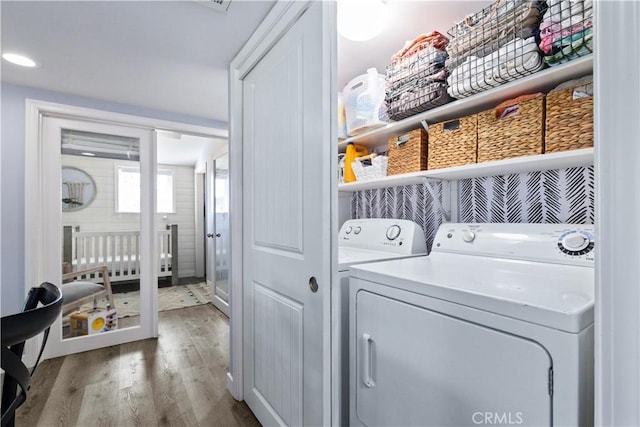 washroom with laundry area, washer and clothes dryer, and wood finished floors