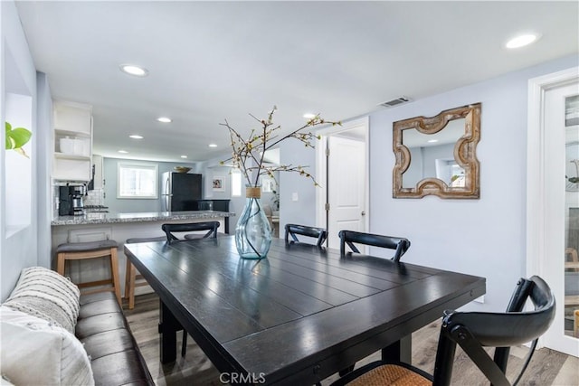 dining room featuring light wood-type flooring, visible vents, and recessed lighting