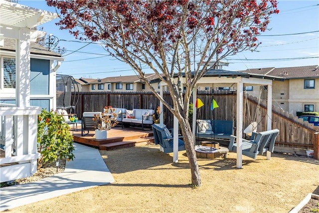 view of yard with an outdoor living space with a fire pit, a fenced backyard, a wooden deck, and a pergola