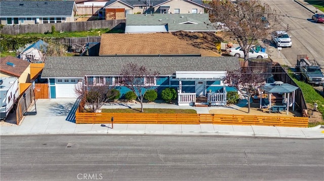 view of front of property with concrete driveway, fence, and a residential view