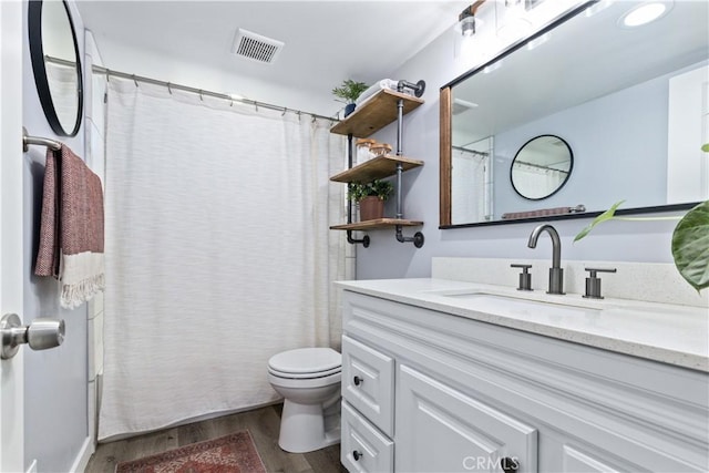 full bathroom with curtained shower, visible vents, toilet, vanity, and wood finished floors