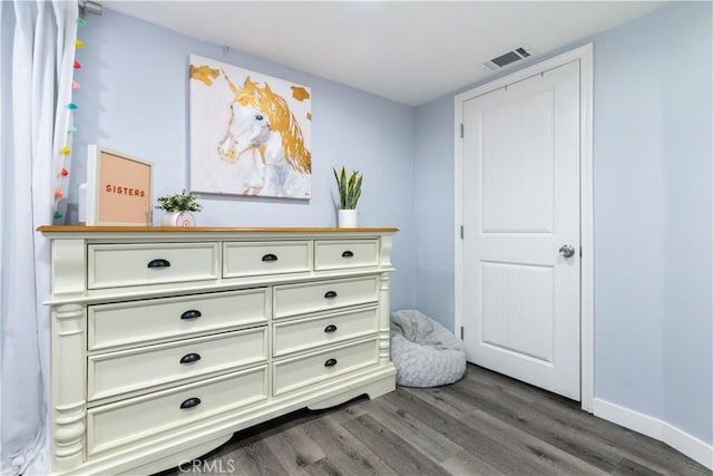 interior space with dark wood finished floors, visible vents, and baseboards