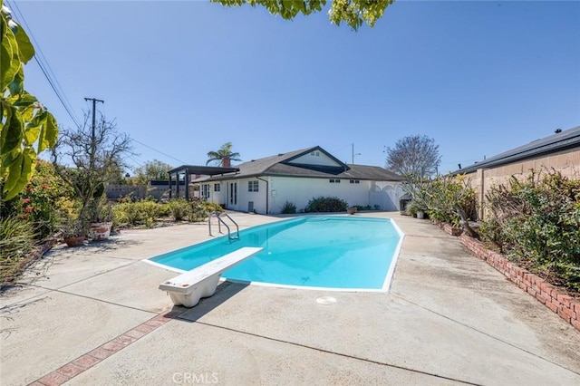 view of pool featuring a diving board, a patio, a fenced backyard, and a fenced in pool