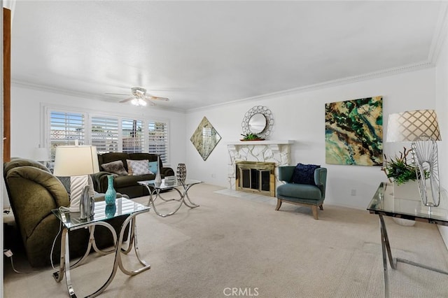 living area with ornamental molding, carpet, a fireplace, and ceiling fan