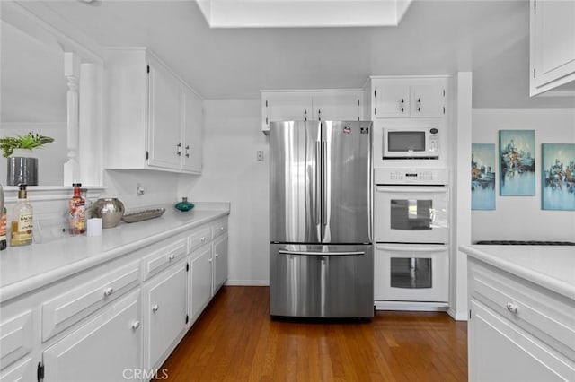 kitchen featuring light countertops, white appliances, white cabinets, and dark wood finished floors