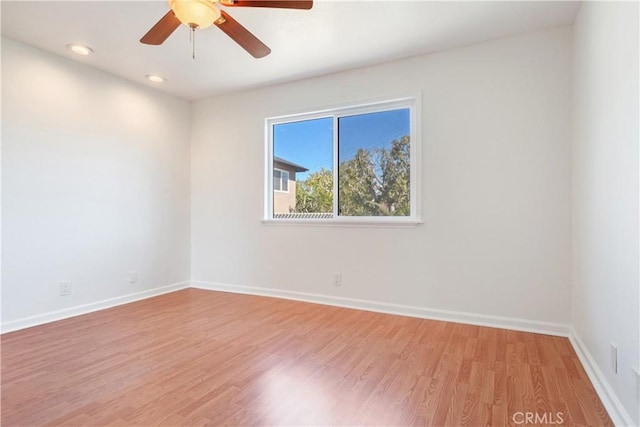 empty room with light wood-type flooring, baseboards, a ceiling fan, and recessed lighting