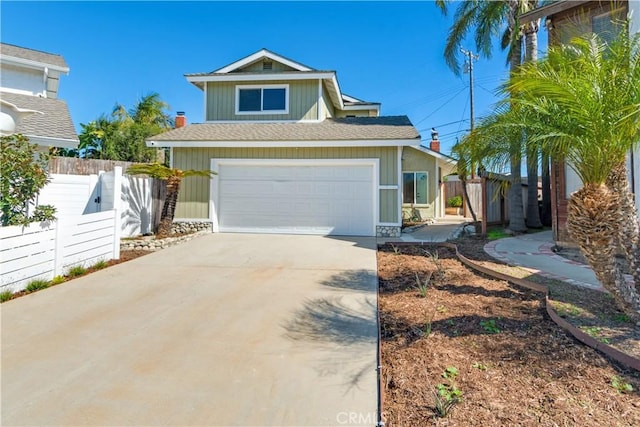 view of front of home featuring driveway, a garage, and fence