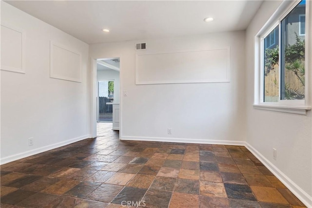 spare room featuring stone tile floors, recessed lighting, visible vents, and baseboards