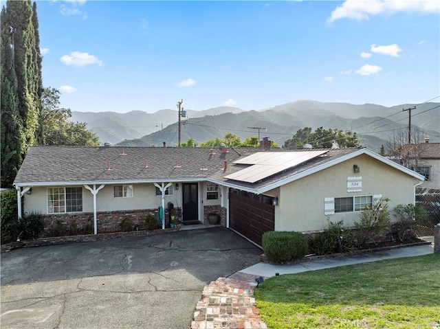 3104 Altura Ave, La Crescenta, CA 91214 - single story home with driveway, an attached garage, a mountain view, stucco siding, and roof mounted solar panels
