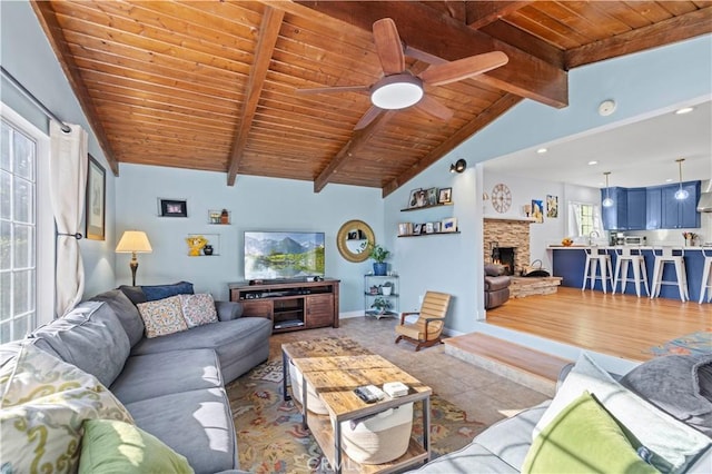 tiled living area with wooden ceiling, vaulted ceiling with beams, a stone fireplace, and baseboards