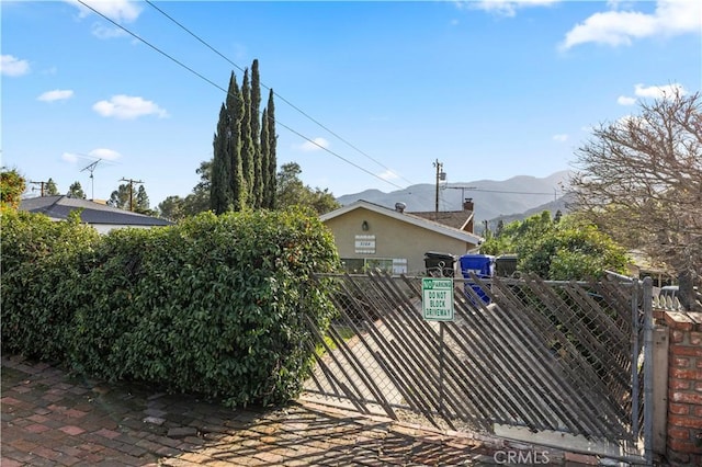 view of gate featuring fence and a mountain view