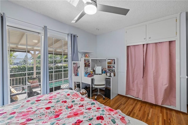 bedroom featuring a closet, a textured ceiling, a ceiling fan, and wood finished floors