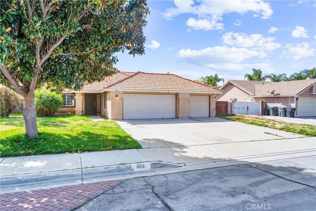 view of front of house with concrete driveway, stucco siding, an attached garage, fence, and a front yard