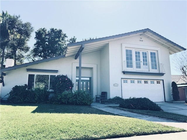 view of front of property featuring stucco siding, concrete driveway, a front lawn, and a garage