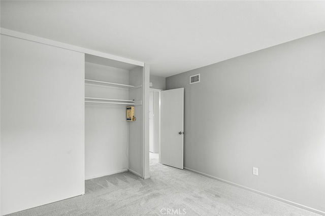 unfurnished bedroom with carpet flooring, visible vents, and a closet