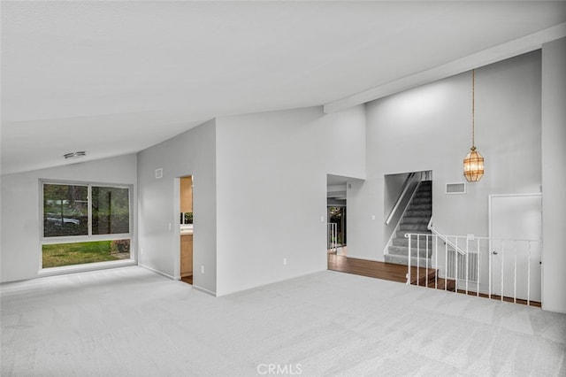 unfurnished living room featuring stairs, carpet, visible vents, and high vaulted ceiling