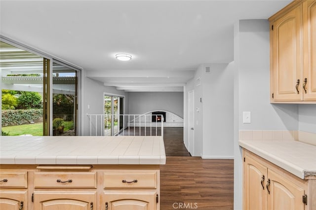 kitchen with baseboards, open floor plan, dark wood-style flooring, and light brown cabinetry