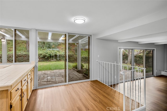 interior space with beam ceiling and wood finished floors