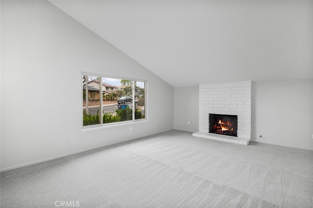 unfurnished living room featuring carpet, a brick fireplace, and high vaulted ceiling