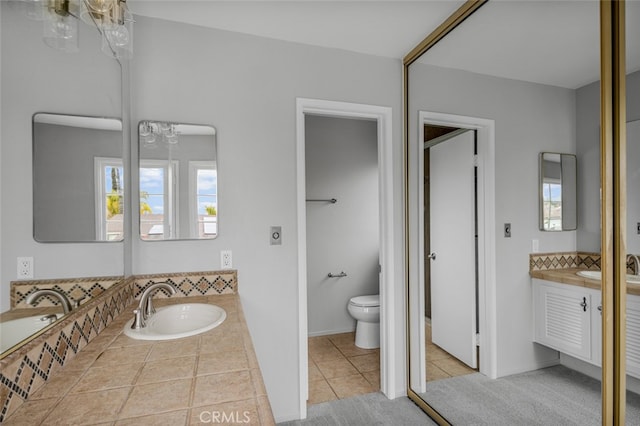 bathroom featuring toilet, vanity, and tile patterned flooring