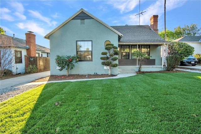 single story home featuring roof with shingles, a front yard, fence, and stucco siding