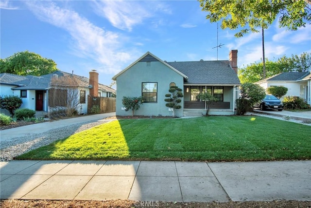 ranch-style house featuring a chimney, stucco siding, a shingled roof, a front yard, and fence