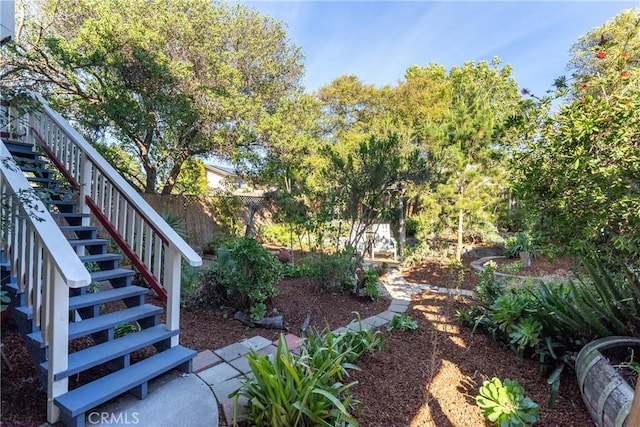 view of yard featuring fence and stairs