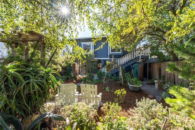 view of yard with stairs, fence, and a pergola