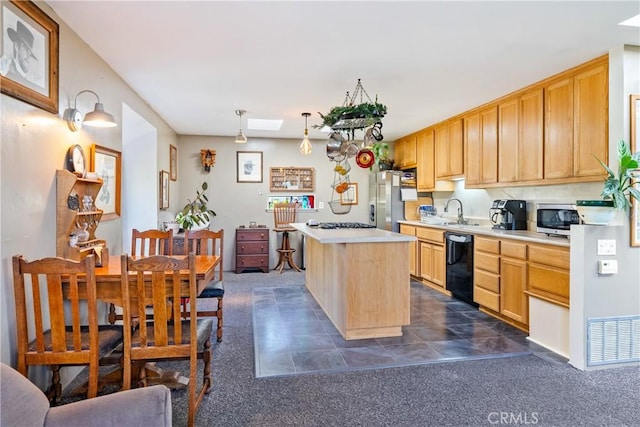 kitchen with light brown cabinets, visible vents, light countertops, appliances with stainless steel finishes, and a center island