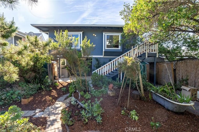 rear view of house with stairs and fence