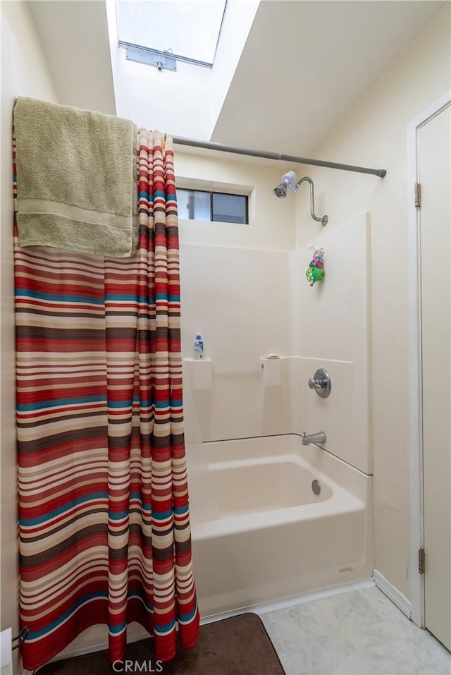 bathroom with a skylight and shower / bathtub combination with curtain