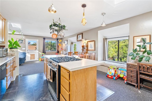 kitchen featuring pendant lighting, appliances with stainless steel finishes, light countertops, and a center island