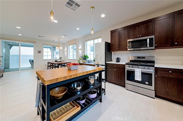 kitchen featuring dark brown cabinetry, visible vents, appliances with stainless steel finishes, and open shelves