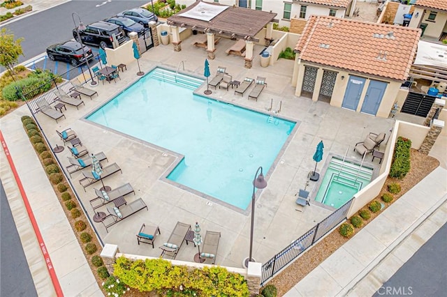 pool with a patio area, a grill, and fence