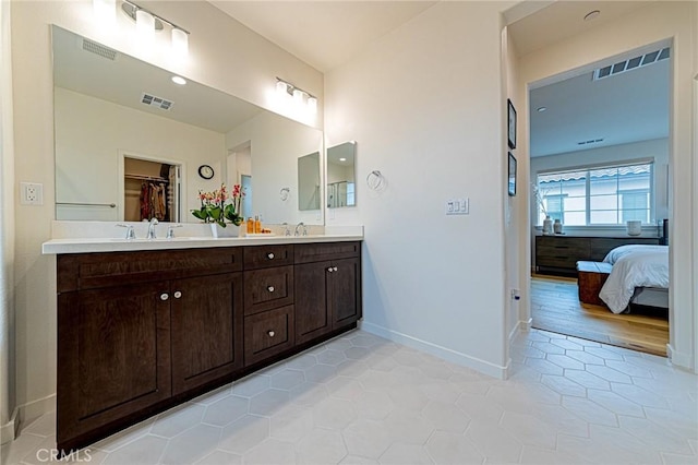 full bath featuring visible vents, ensuite bathroom, baseboards, and a sink