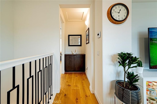 corridor with baseboards and light wood finished floors