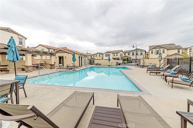 community pool featuring a pergola, fence, a residential view, and a patio