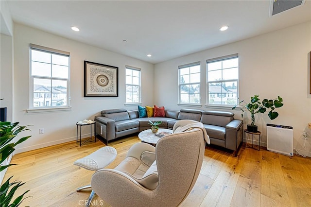 living room with recessed lighting, light wood-type flooring, and baseboards