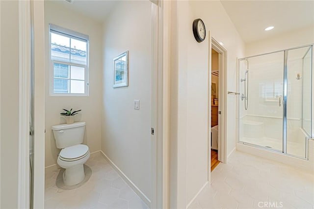 bathroom with tile patterned floors, baseboards, toilet, and a stall shower