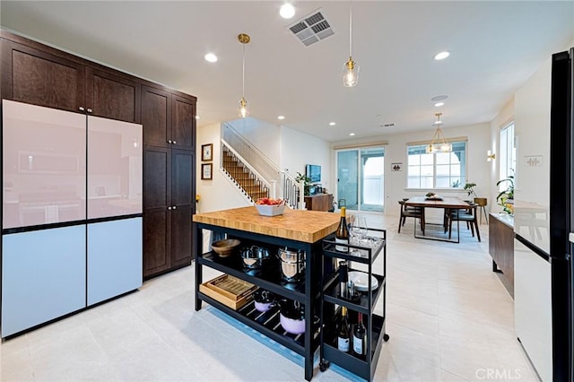 kitchen featuring visible vents, white refrigerator, dark brown cabinetry, pendant lighting, and recessed lighting