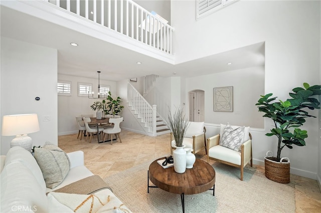 living area with a high ceiling, stairs, baseboards, and recessed lighting