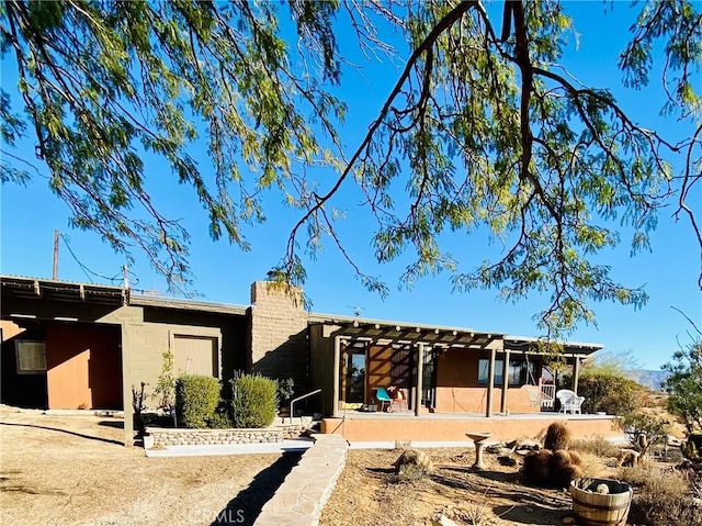 back of house featuring a patio and a chimney