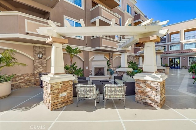 view of patio with an outdoor living space with a fireplace