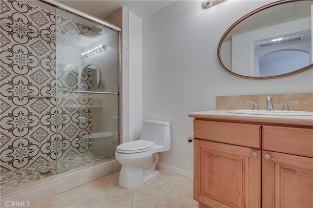 bathroom featuring tile patterned flooring, toilet, vanity, baseboards, and a tile shower